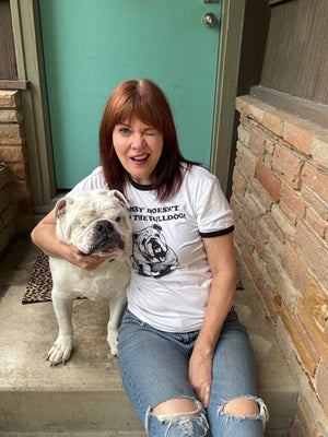 Woman holding her pet bulldog and wearing a bulldog t-shirt