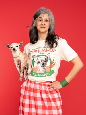 A Woman holds a chihuahua while wearing Pet Rodeo's Spicy Chihuahua t-shirt in front of a red background
