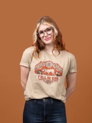 A woman wearing Pet Rodeo's vintage western graphic tshirt that says Y'all Be Kind