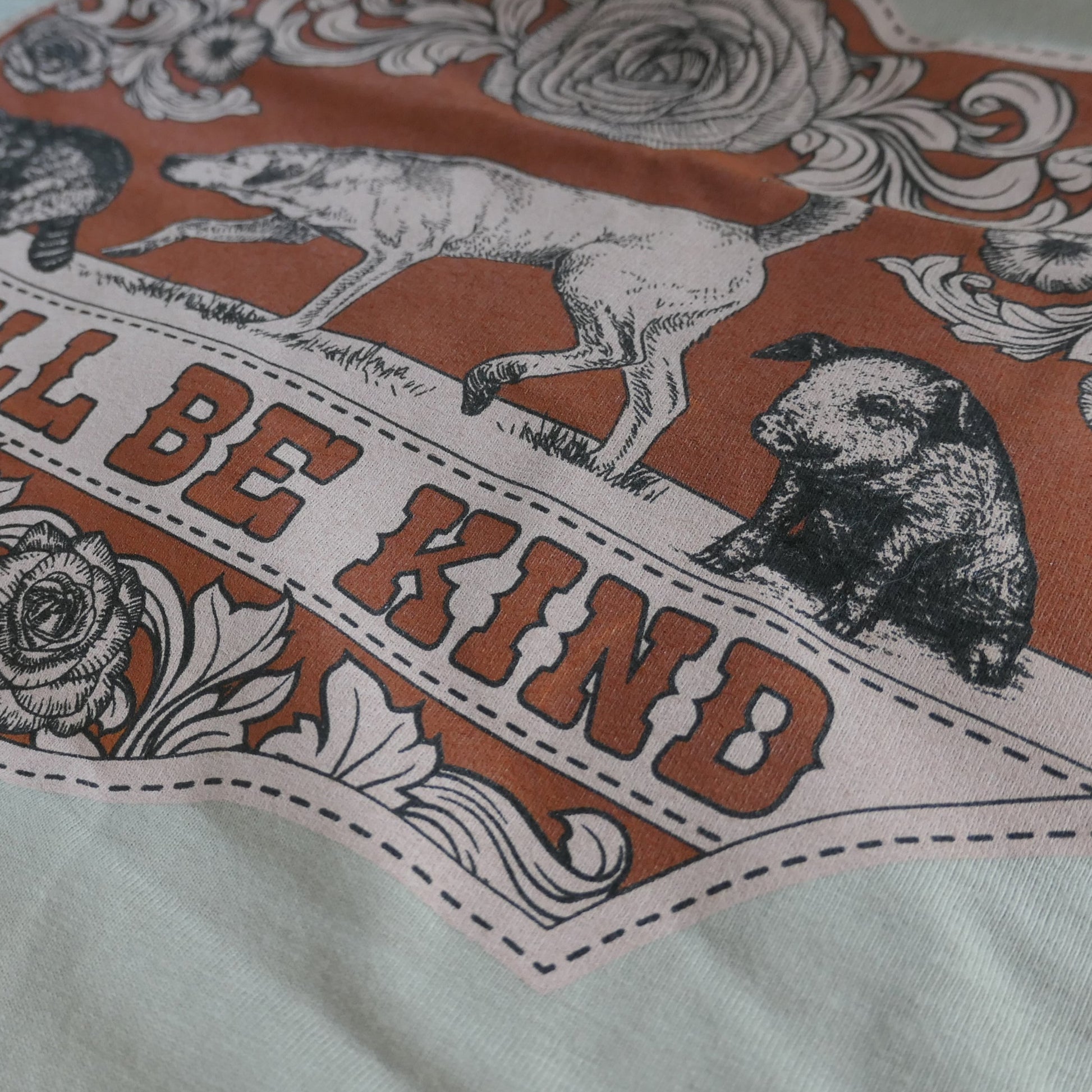 Detailed close up of Y'all Be Kind illustration on a t-shirt