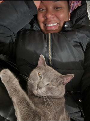 Woman and her cat lying together looking at the camera: pets are family