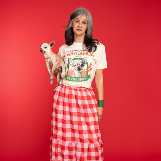 Woman wearing a chihuahua tee shirt and holding an elderly chihuahua against a red background