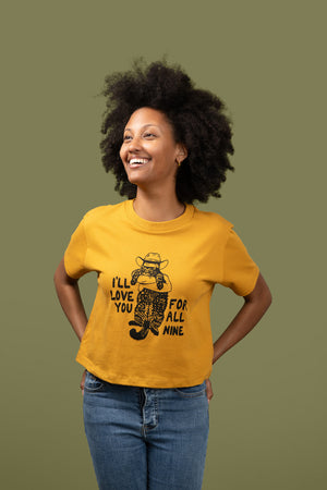 Woman wearing a yellow t-shirt with a graphic design and text, standing against a solid background