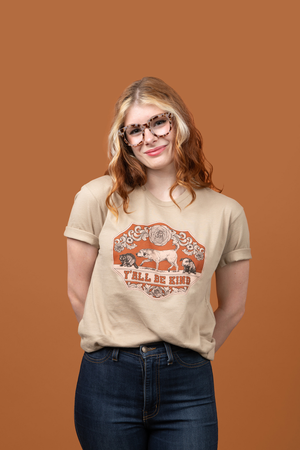 A woman wearing Pet Rodeo's vintage western graphic tshirt that says Y'all Be Kind