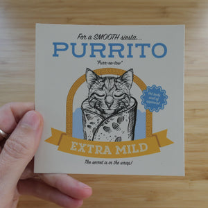 Hand holding a vinyl, 4 inch sticker that says Purrito with a cat illustration