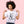 Woman wearing a lavender t-shirt with a graphic of a cat and text, standing against a pink background