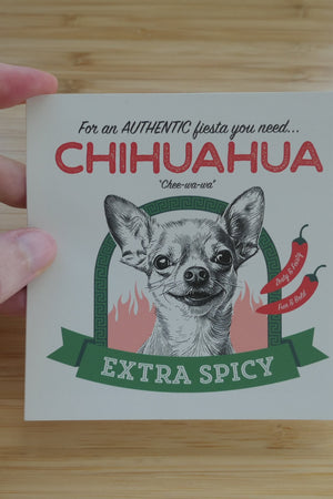 someone holding a 4 inch, Spicy Chihuahua vinyl sticker against a wooden background