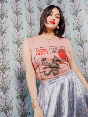 Woman wearing a Cat Wrangler Rodeo Tank Top against a patterned background