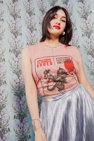 Woman wearing a Cat Wrangler Rodeo Tank Top against a patterned background